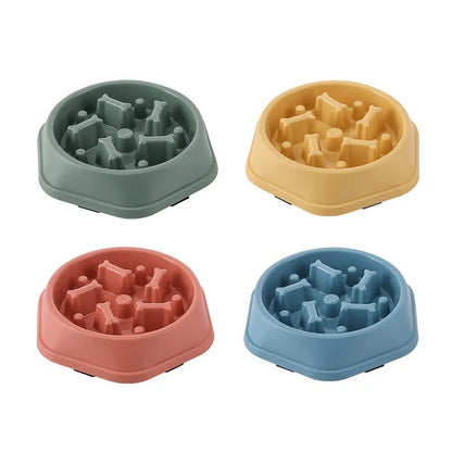 Four colorful anti-choke slow feeder dog bowls in red, green, yellow, and blue arranged together