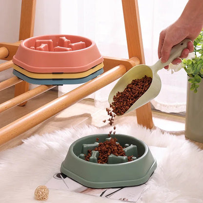 Pouring dry dog food from a scoop into a green anti-choke slow feeder maze bowl