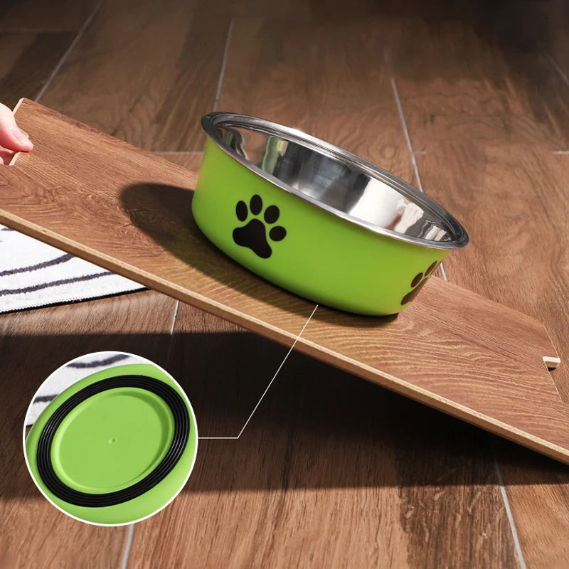 Green stainless steel dog bowl on a slanted wooden board showing the rubber non-slip base